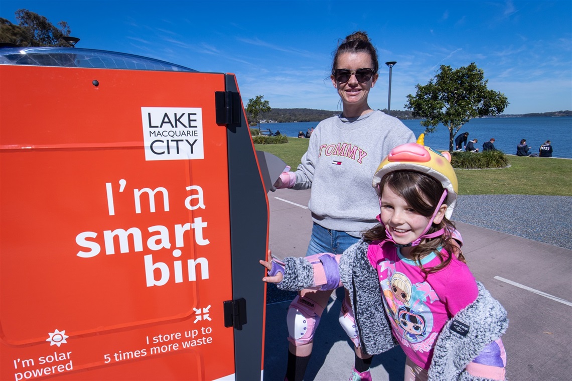 Elle Sharp and daughter Myra, 8, test out one of the new smart bins at Warners Bay foreshore.jpg