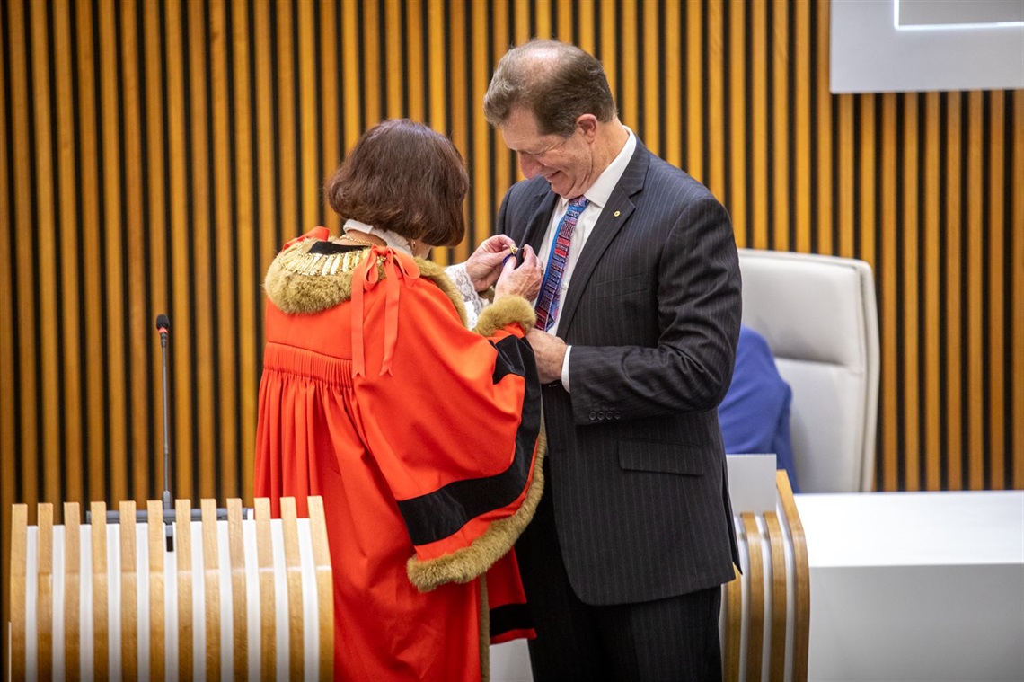 Mayor Kay Fraser pins the Freeman of the City medal onto Dr Durrheim's jacket.jpg